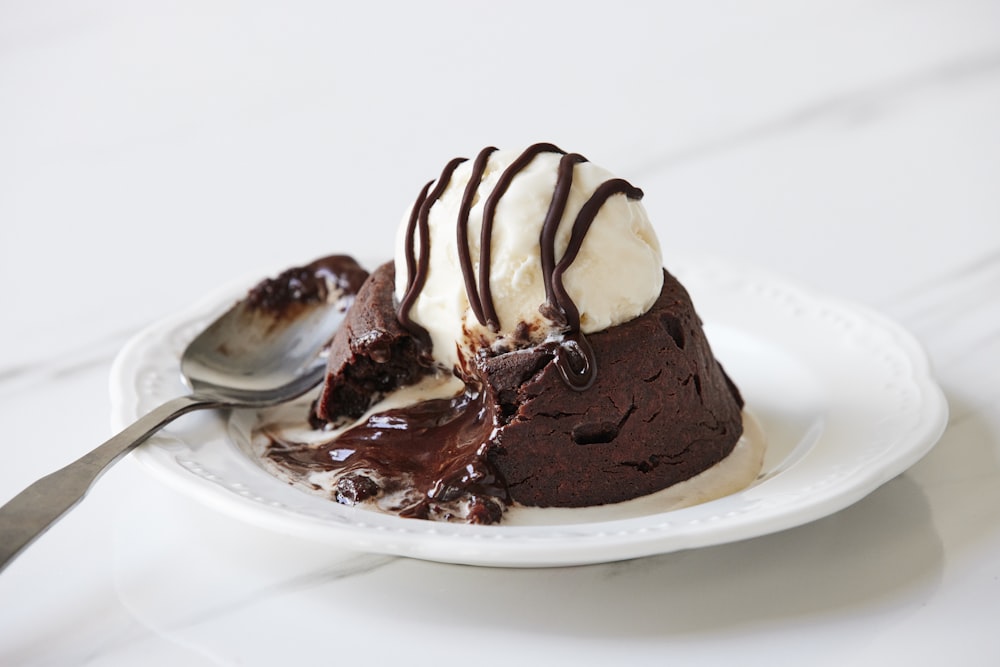 a white plate topped with a piece of cake and ice cream