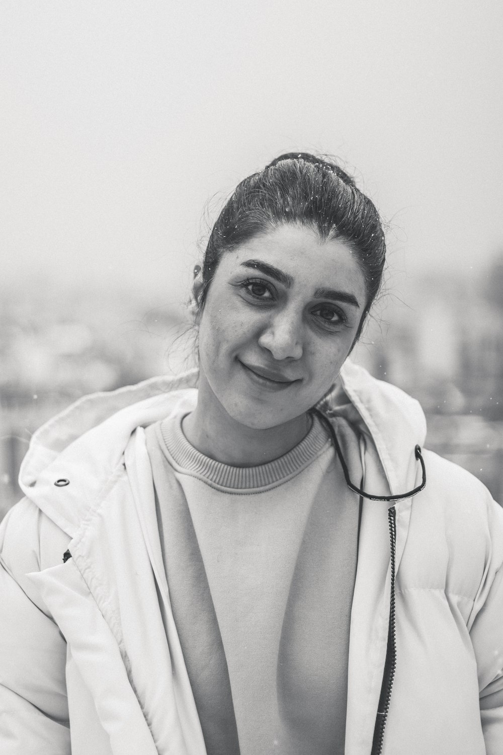 a black and white photo of a woman wearing a jacket