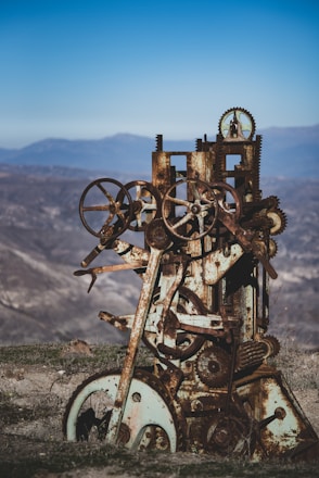 a rusted out machine sitting on top of a hill