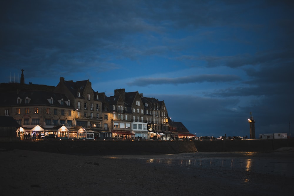 a row of buildings on a beach at night