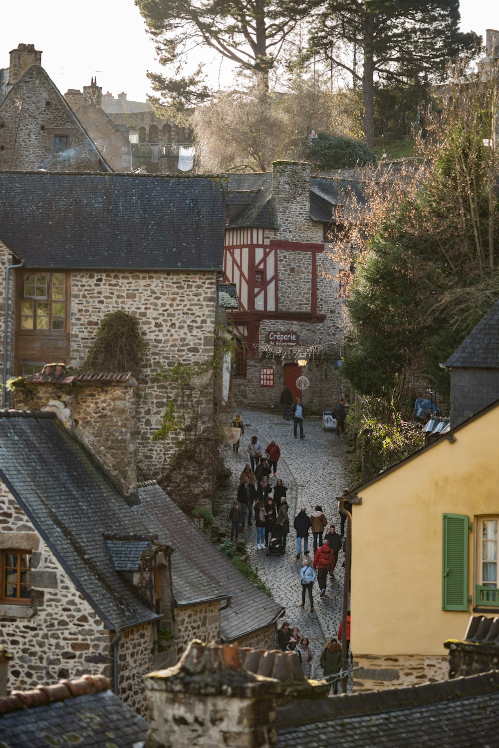 a group of people walking down a cobblestone street