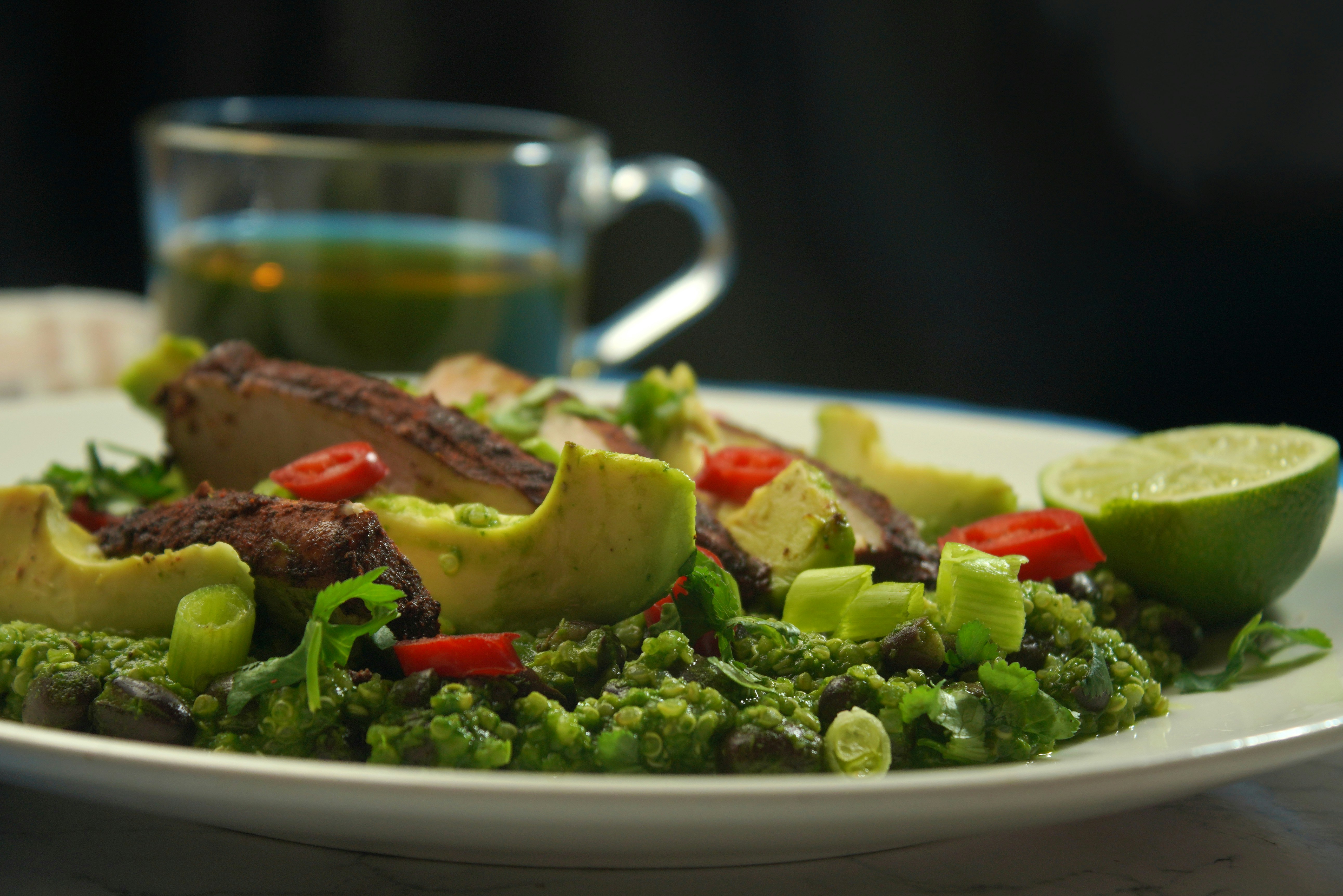 a white plate topped with a salad and a cup of tea