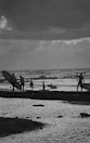 Group of friends carrying surfboards walking to the beach