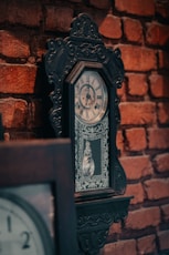 a clock that is on the side of a brick wall