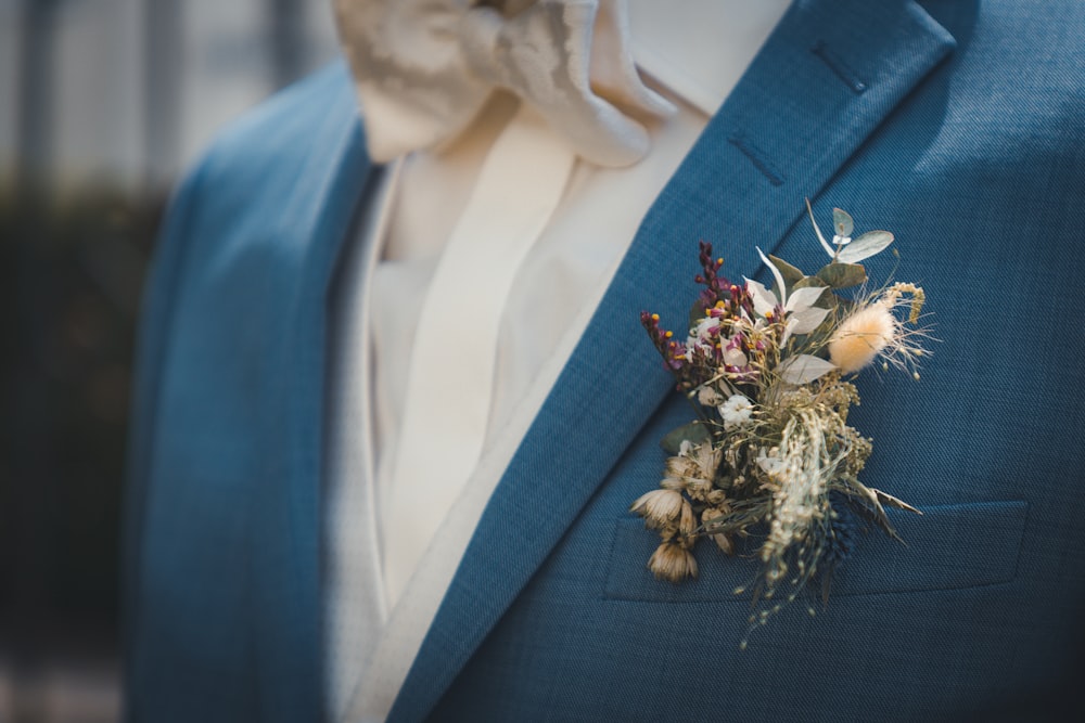 a man in a blue suit with a boutonniere on his lapel