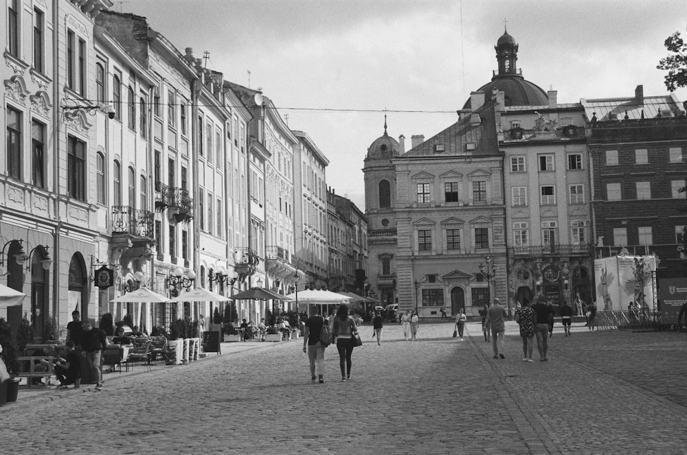 a black and white photo of people walking down a street