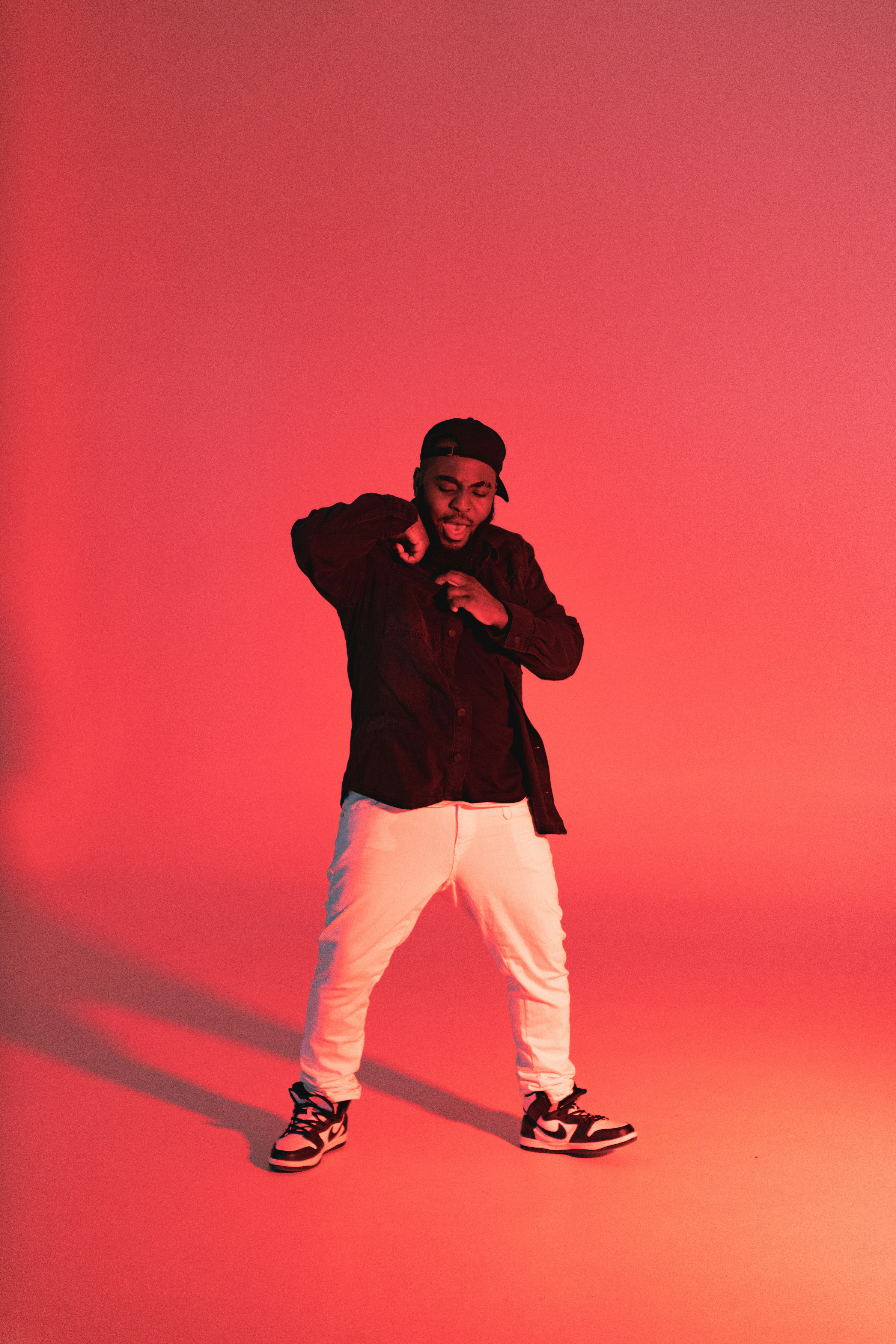 A rapper performing on stage under a single spotlight.