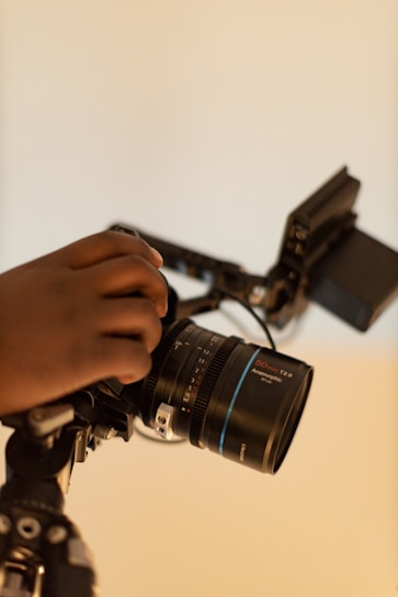 a person holding a camera on a tripod