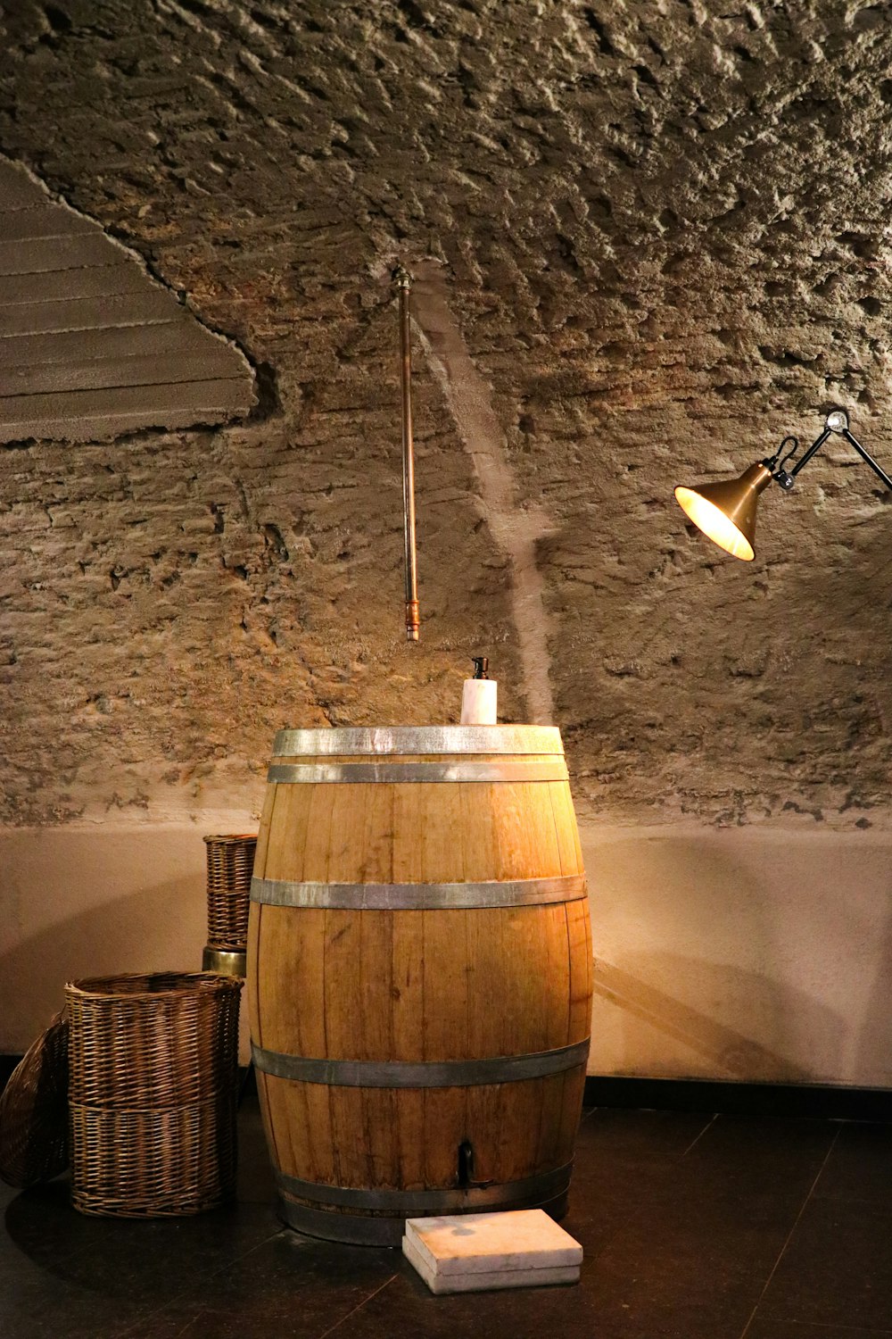 a wooden barrel sitting in a room next to a lamp