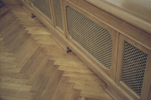 Renovated indoor window sill with a fresh plastic finish alongside a custom-cut radiator grille