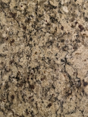 The surface displays a speckled pattern with various shades of brown, black, and cream, typical of a granite countertop.