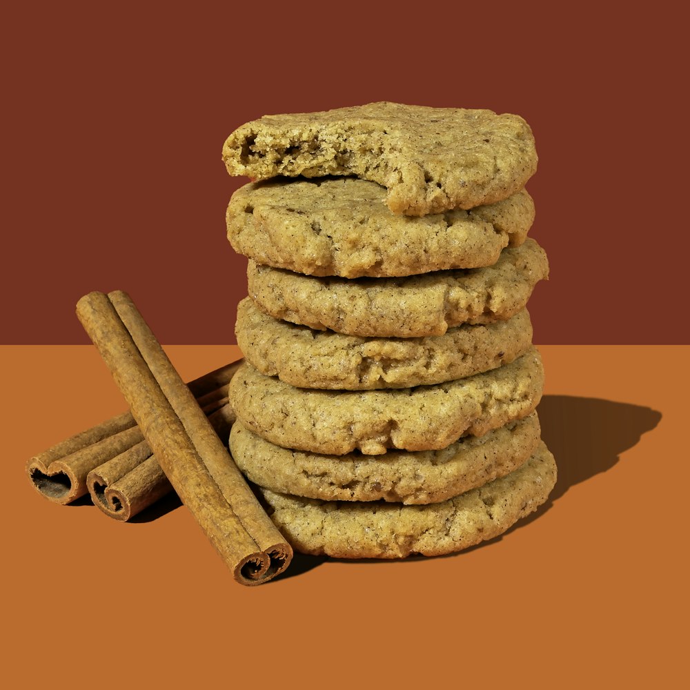 a stack of cookies next to cinnamon sticks