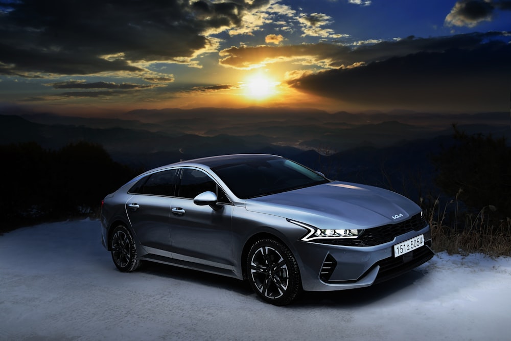 a silver car parked on top of a snow covered slope