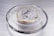 A metallic Bitcoin coin is prominently displayed on a sleek, reflective surface. The coin features detailed circuit-like patterns and the iconic Bitcoin logo. It is encased in a transparent ring, adding to its futuristic and technological appeal.