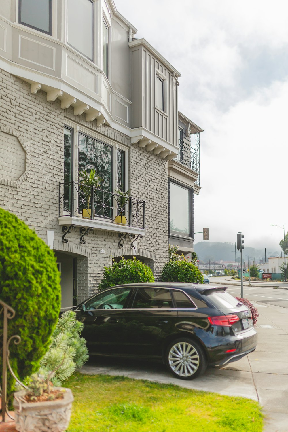 a black car parked in front of a brick building