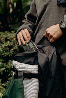 An outdoor enthusiast’s backpack open to reveal a power bank connected to a GPS device on a forest trail.