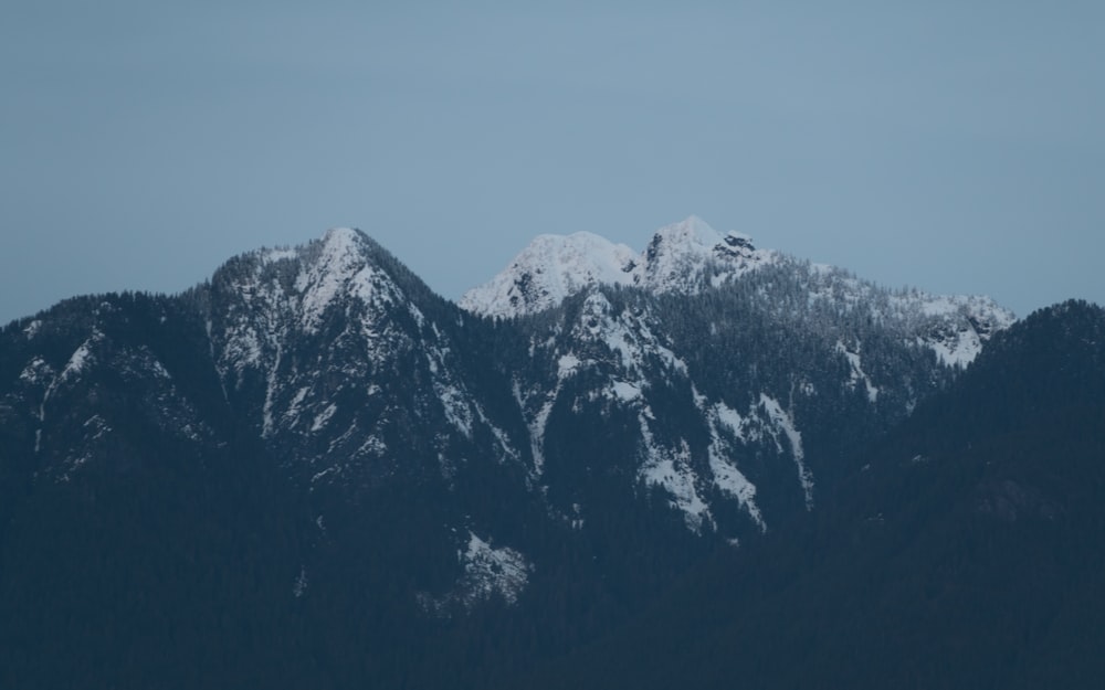 a mountain range with snow covered mountains in the background