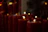 Golden and burgundy candles glowing softly on a peaceful memorial site at dusk.