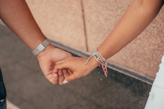 a close up of two people holding hands