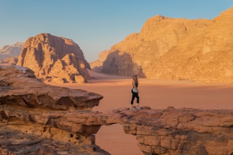 a person standing on a rock in the desert