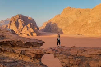 a person standing on a rock in the desert