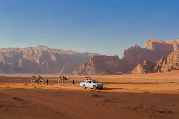 A panoramic view of the rugged desert landscape during the Ras Mohammed land safari, with a 4x4 vehicle in the foreground.