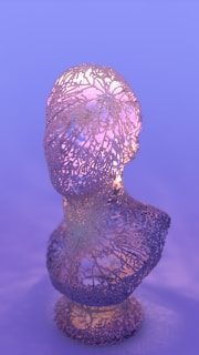 Close-up of a feminine handmade sculpture glowing softly under warm light