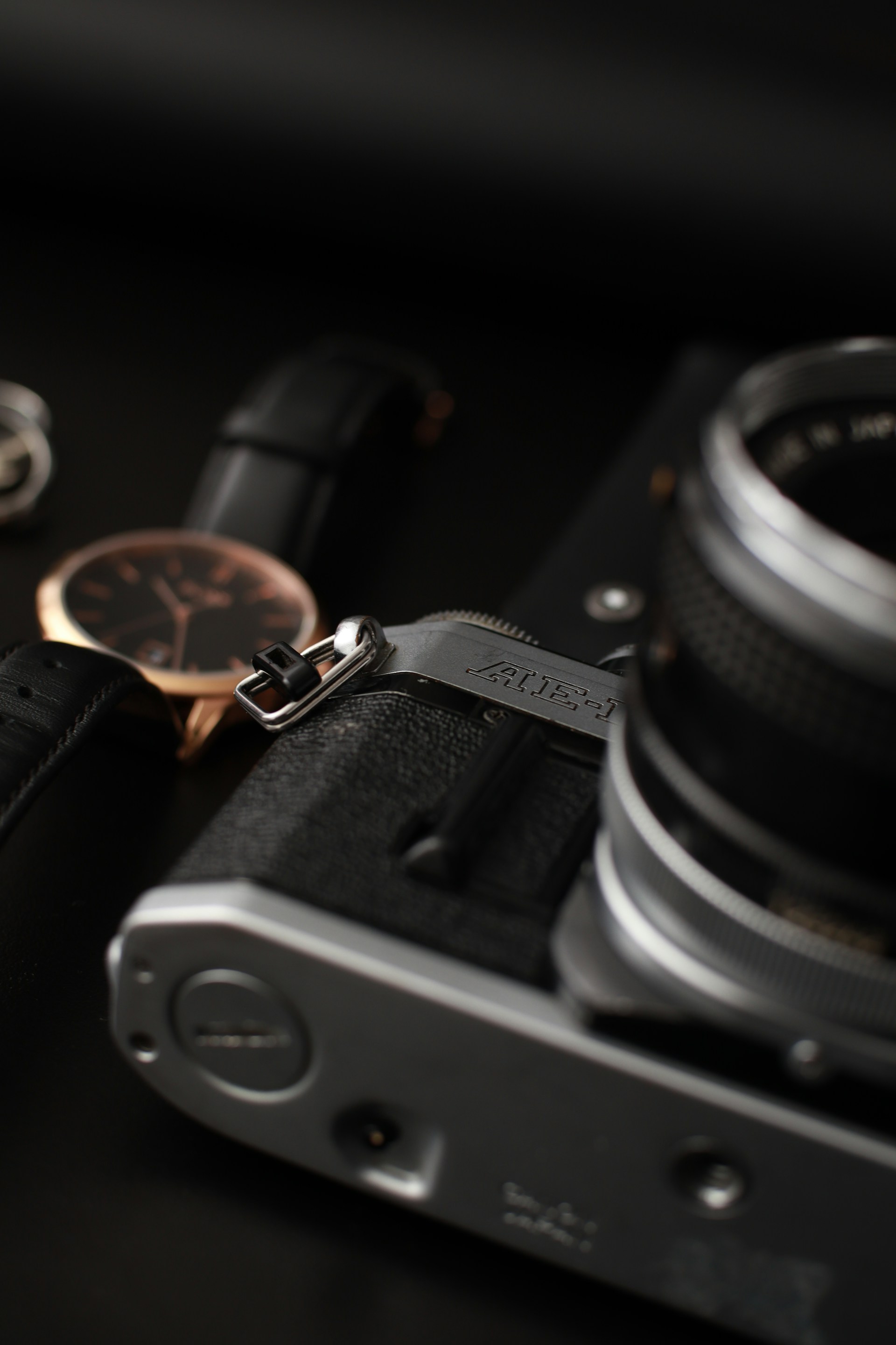 A Timelens watch resting on a wooden table beside a vintage camera, capturing a timeless blend of craftsmanship and nostalgia.