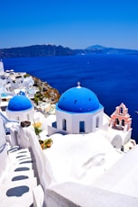 a view of a blue domed building on the edge of a cliff