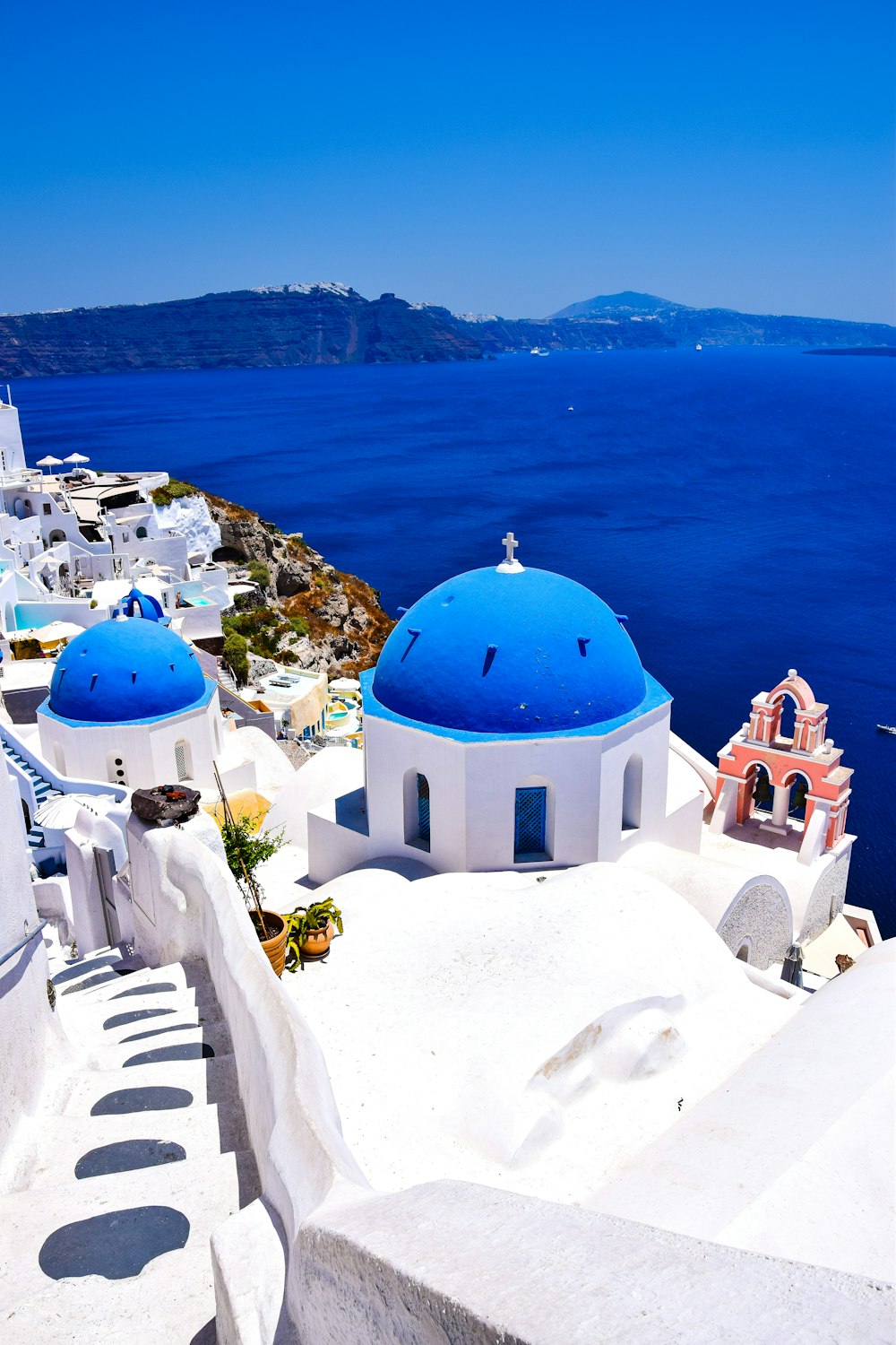 a view of a blue domed building on the edge of a cliff