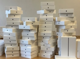Warehouse shelves filled with sealed Apple products ready for shipment.