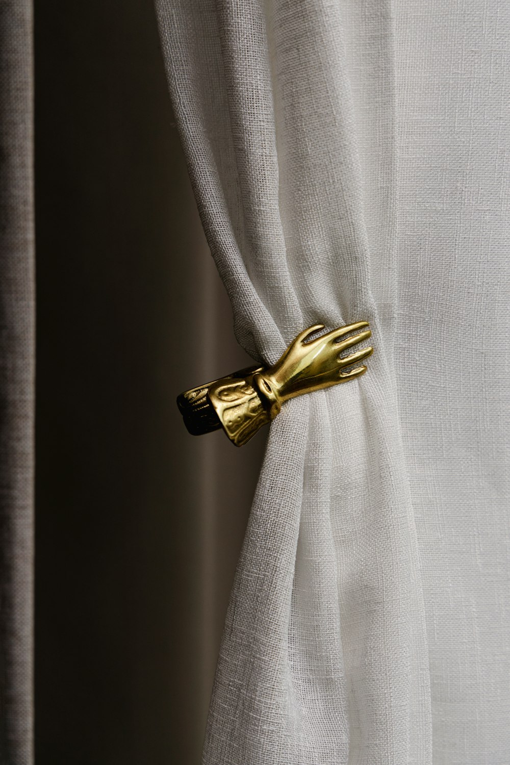 a curtain with a gold glove on it