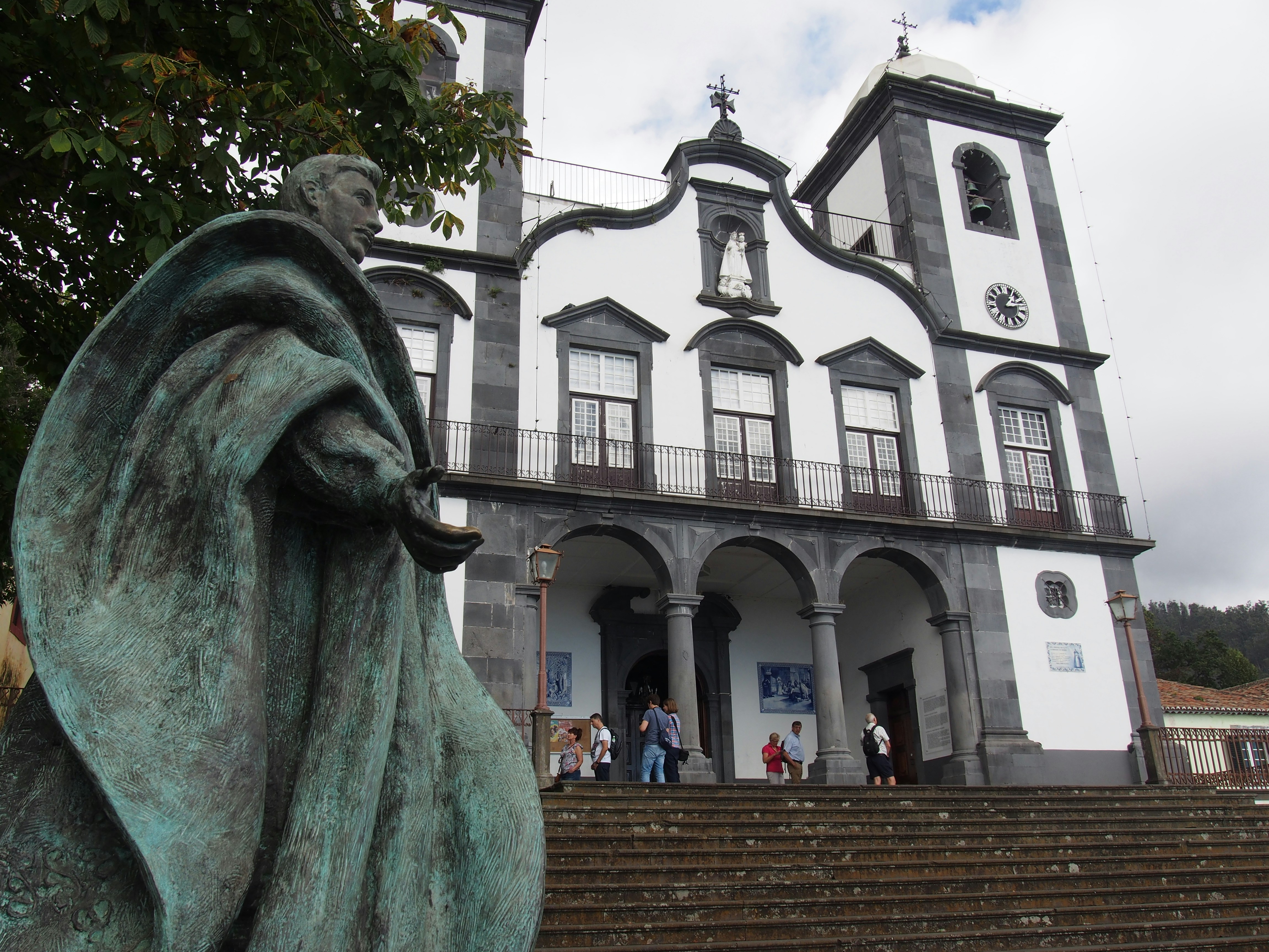 a statue in front of a building with a clock tower