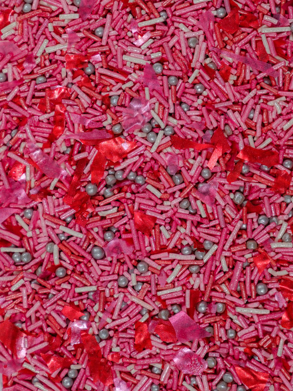 a pile of red and pink sprinkles on a table