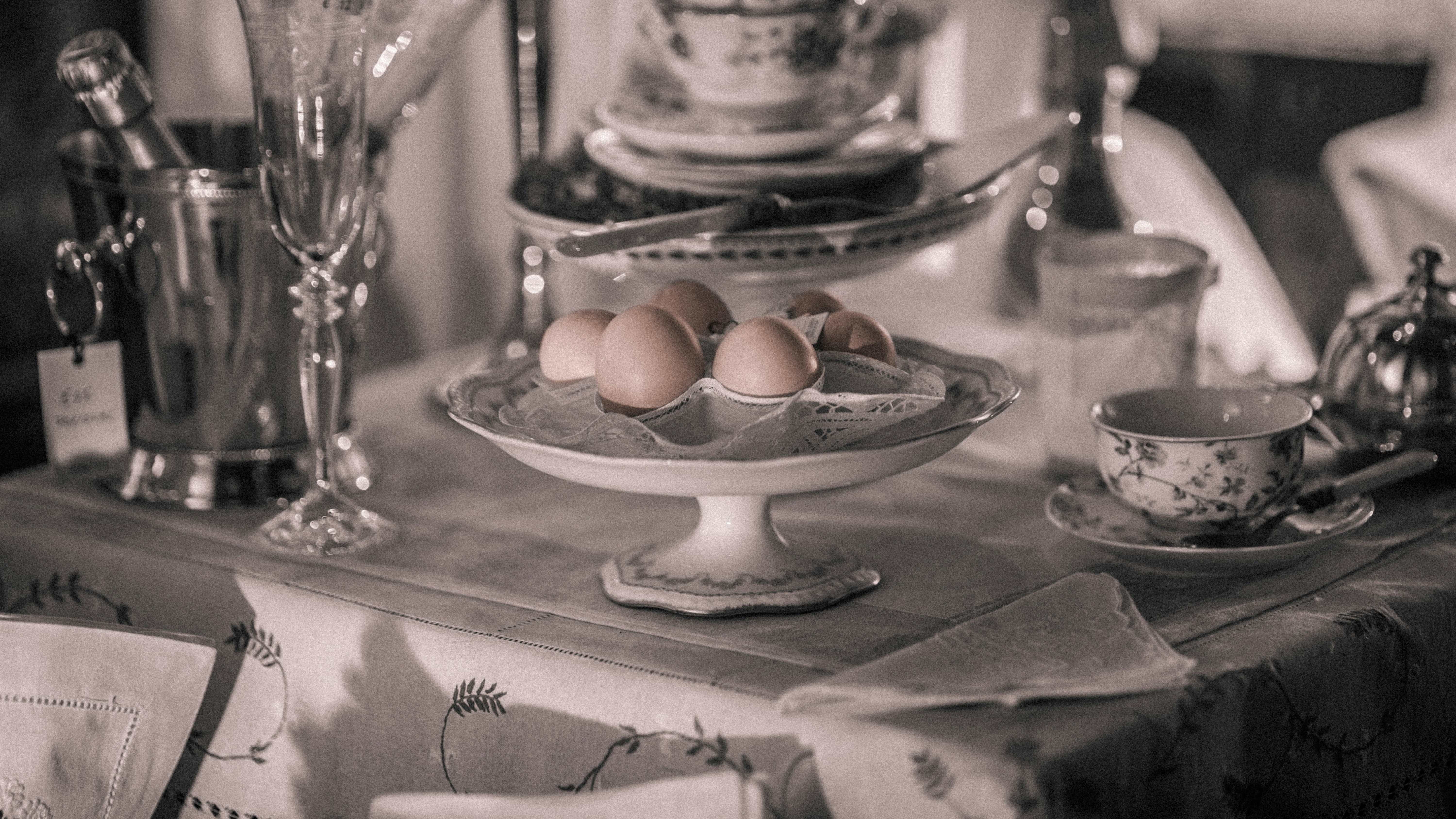 Black and white photo of eggs and tea on a table