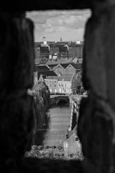 a black and white photo of a river and buildings