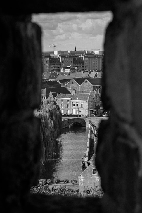 a black and white photo of a river and buildings
