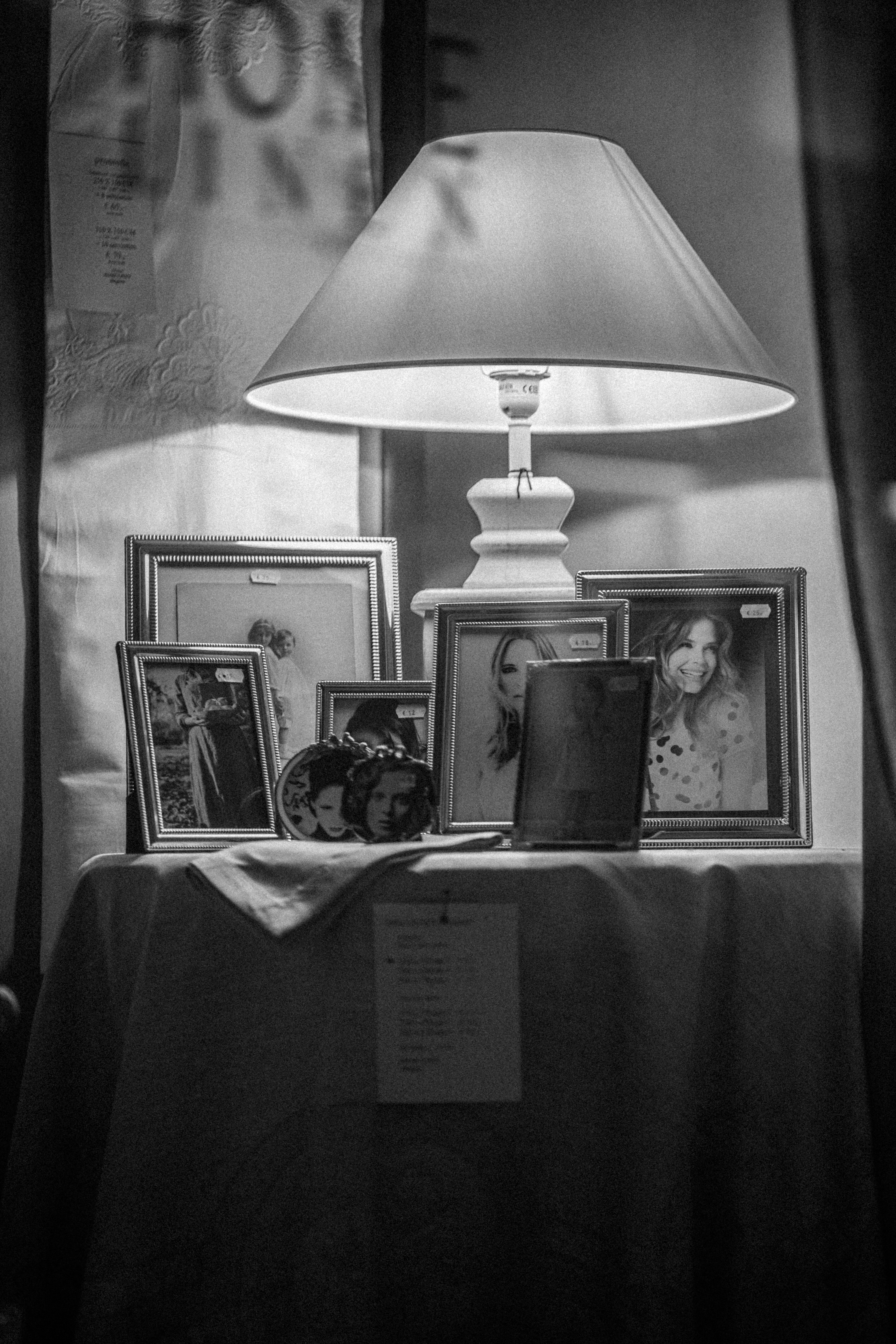 Eine Lampe sitzt auf einem Tisch neben Bildern