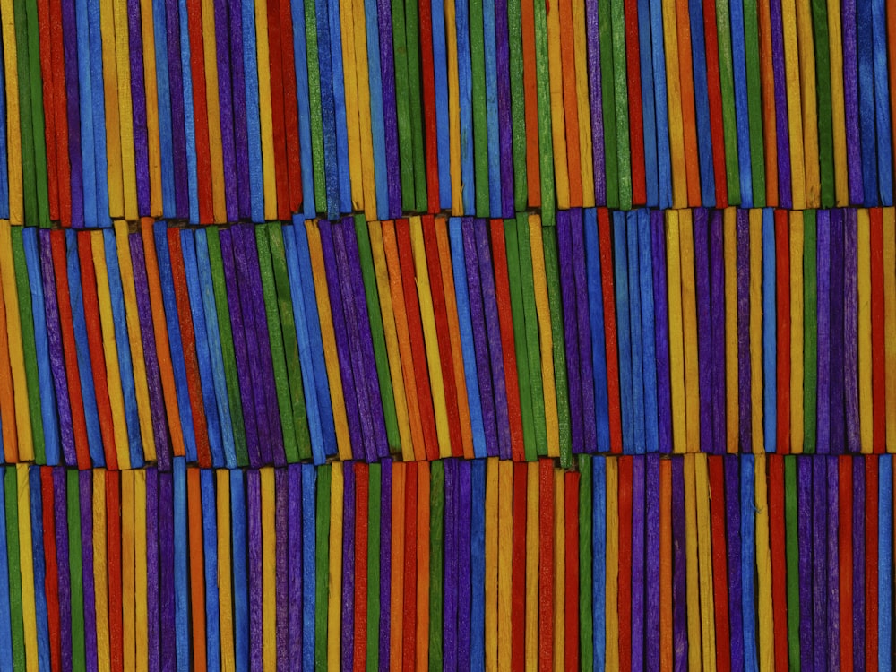 a close up of a multicolored wall made of strips of yarn