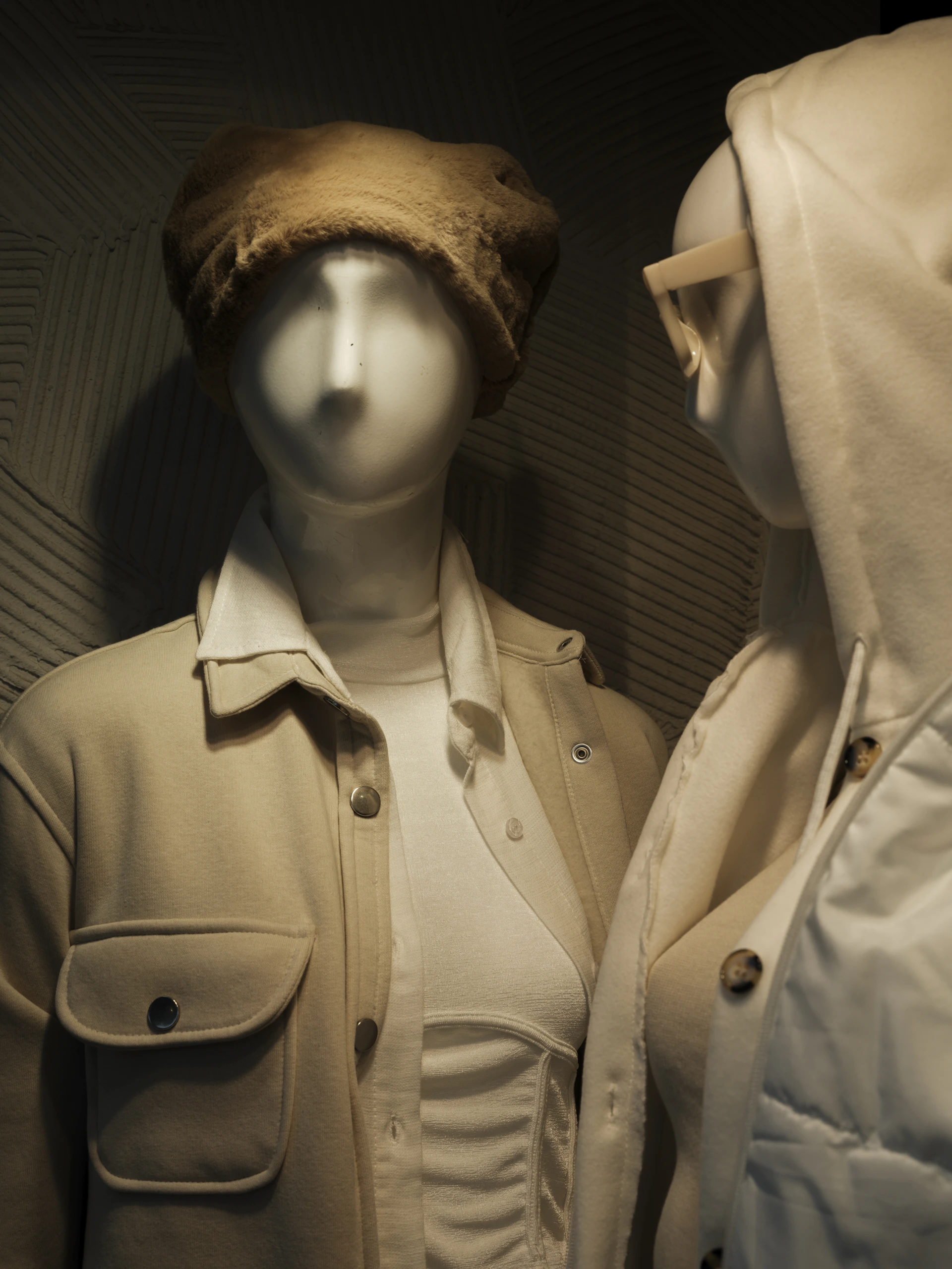two mannequins dressed in coats and hats