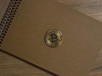 a brown notebook with a bitcoin on it
