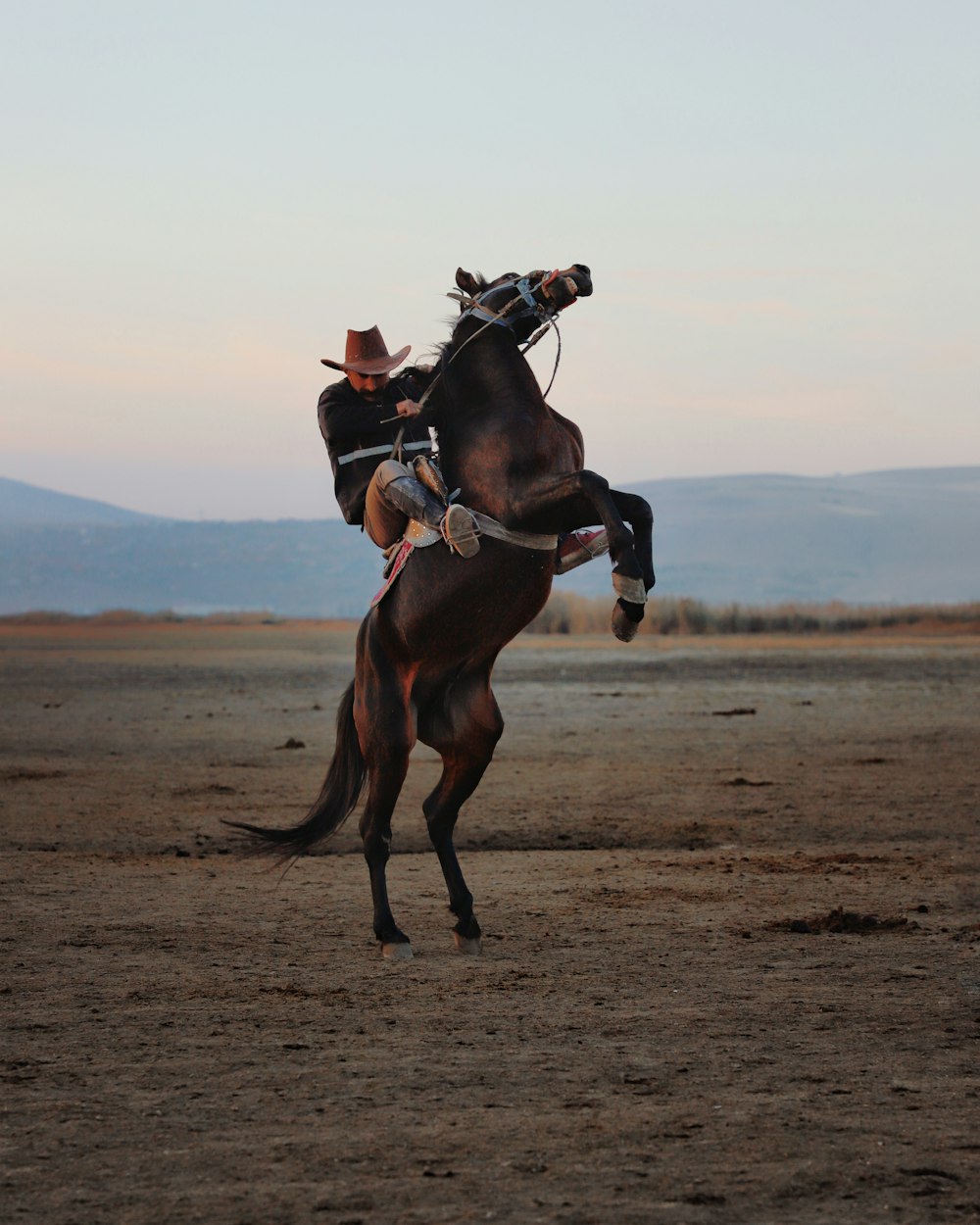 a man riding on the back of a brown horse