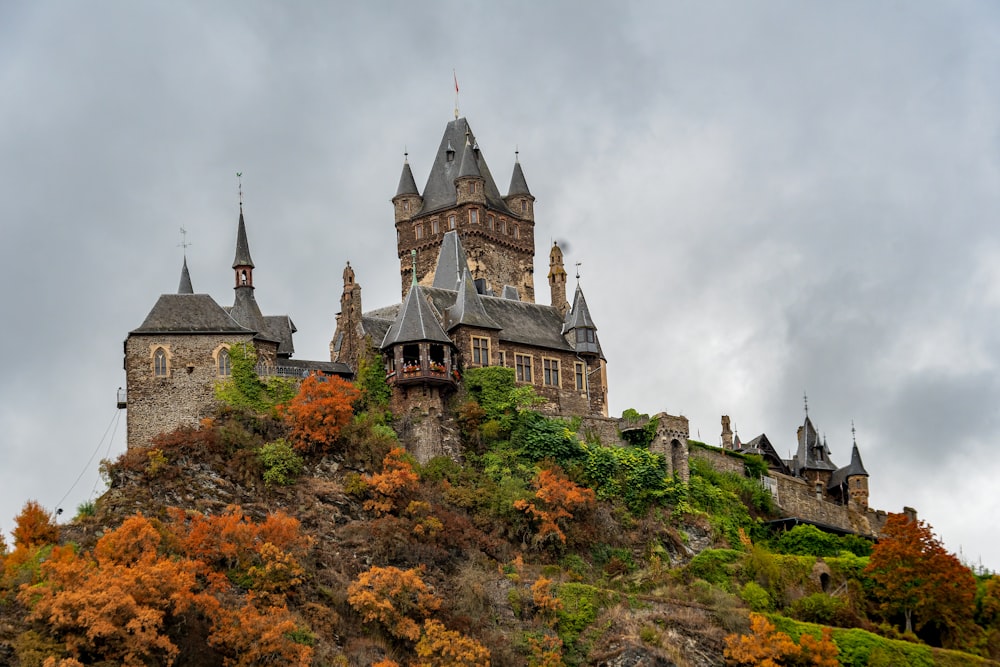 Un castillo en la cima de una colina rodeado de árboles