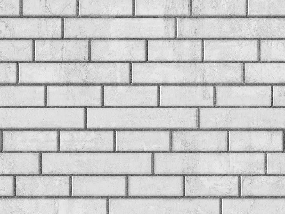 uma parede de tijolo branco texturizada com tijolos cinza claro