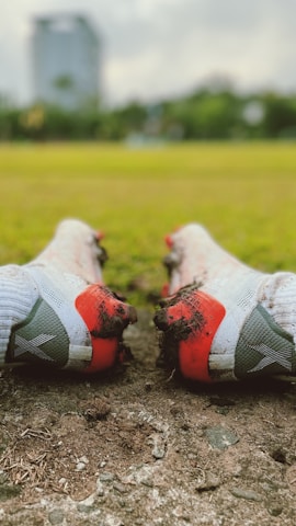 Close-up of rugby boots on a muddy pitch during a match.