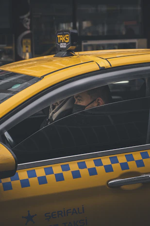 A close-up of a taxi meter and steering wheel inside a Yakuplu Korsan Taksi vehicle.