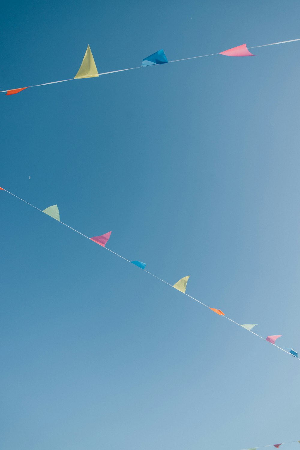 a group of kites flying in a blue sky