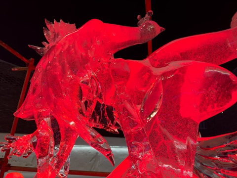 An intricate ice sculpture of a company logo displayed at a gala.