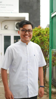 Happy customer wearing a custom embroidered dress shirt, smiling outdoors.