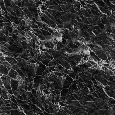 A textured black marble surface with intricate white veining patterns creating a sophisticated and elegant appearance.